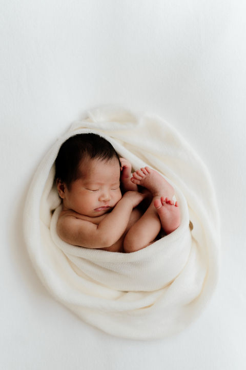 newborn photographed in a blanket