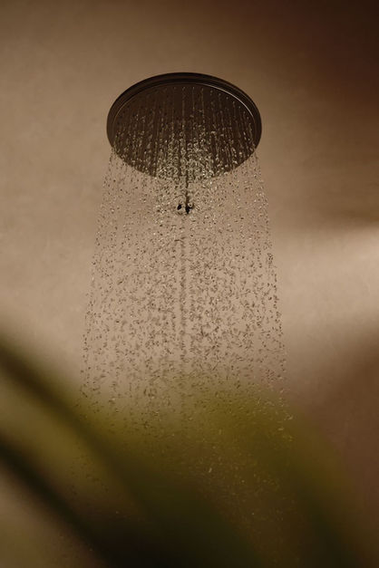Ceiling-mounted showerhead with cascading water droplets.