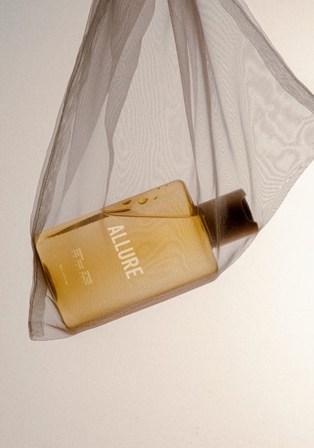 Perfume bottle wrapped in sheer fabric.