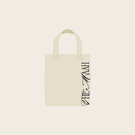 Beige tote bag with vertical black text design.