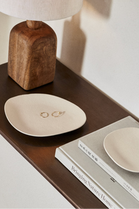 organic white dish for jewelry on brown table