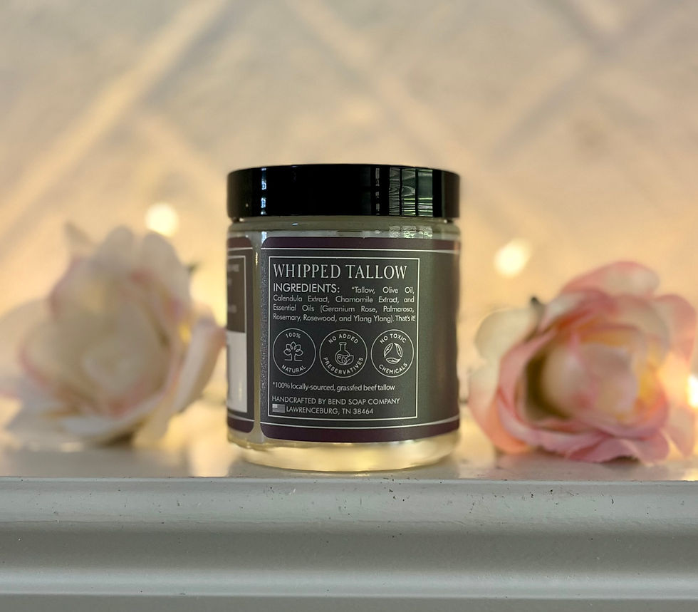 Bend Soap Co. Silk & Tallow Meadow scent. Side of jar list of exclusions. Fairy lights, pink roses, & white brick backdrop.