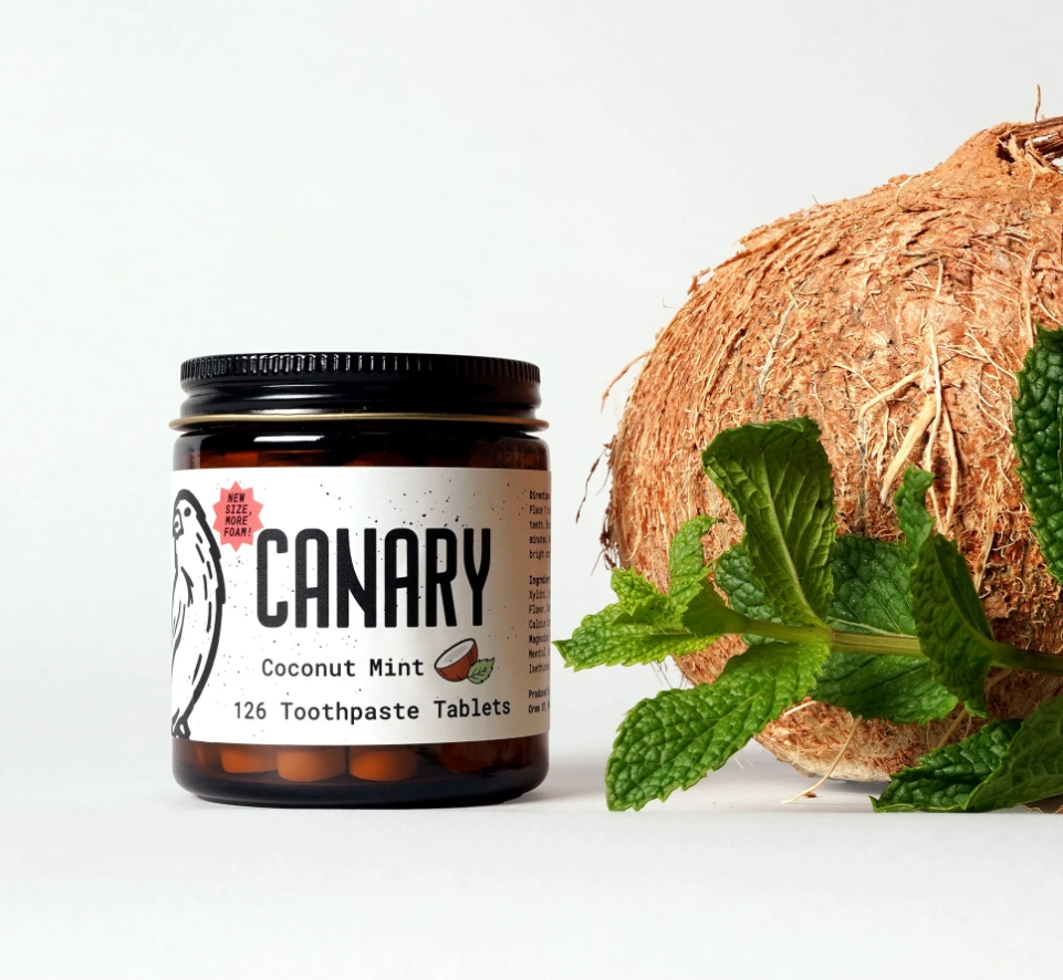 Thumbnail: Coconut Mint Canary Toothpaste Tablets. Glass jar 126 count displayed with a coconut and sprig of mint.