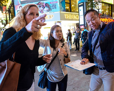 Business travelers looking at a map in one of Taipei busy neighbourhoods.