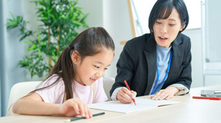 小学生の女の子に勉強を教える社会人プロ講師