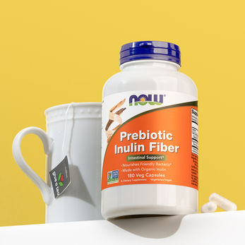 Supplement Bottle with tea cup and pills next to the bottle.