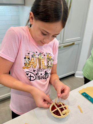 preteen girl stands at kitchen counter making latte pie crust