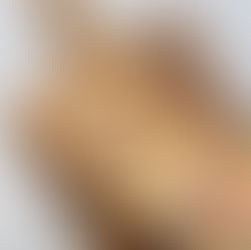 Eye-level view of a loaf of freshly baked rainbow sprinkle bread on a wooden cutting board