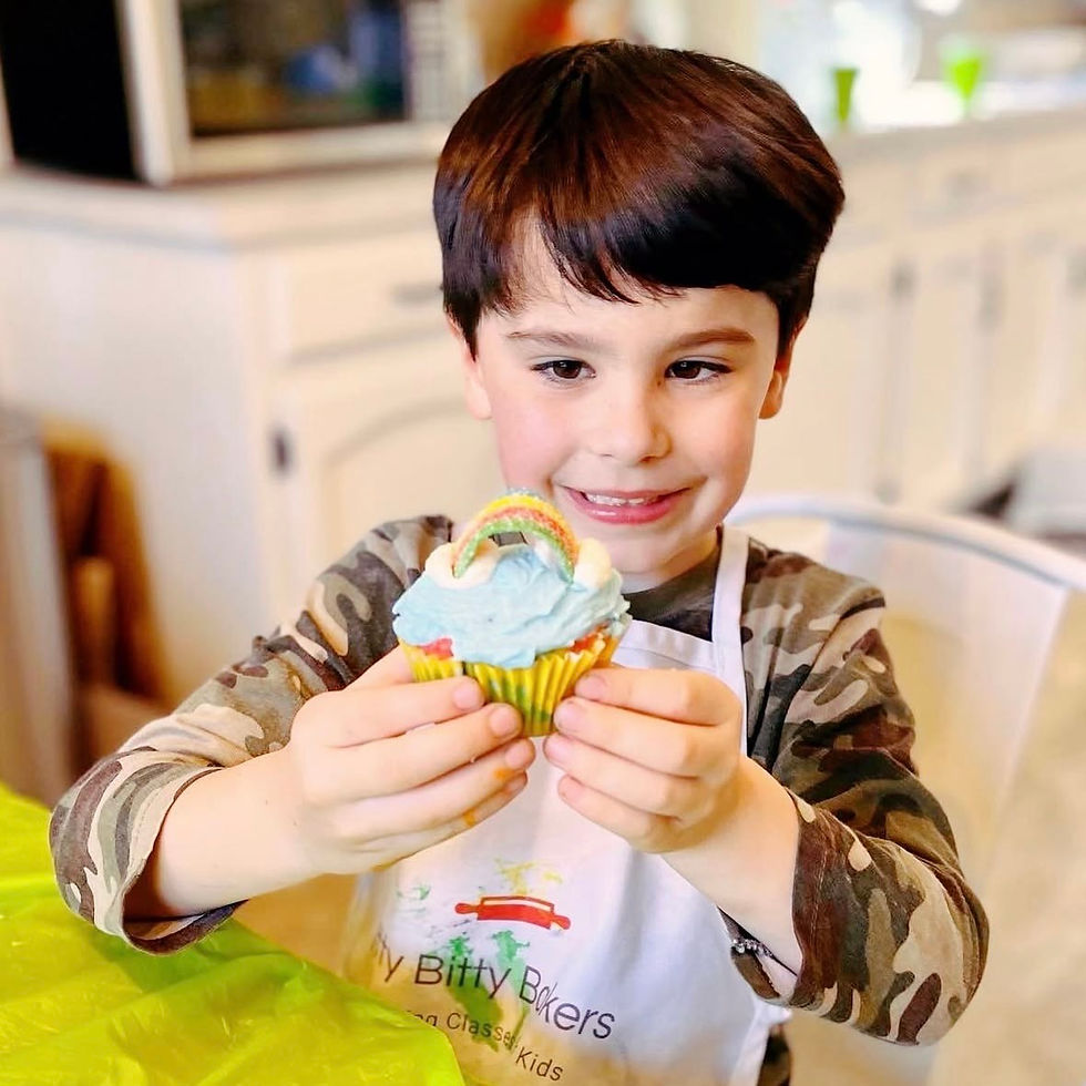 boy holds a rainbow cupcake at a kids baking class in birmingham alabama