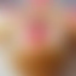 Four mini pineapple upside-down cakes on a wooden surface, topped with red cherries. Warm tones, moist texture, sweet and inviting.