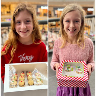 two girls holding their boxes of christmas cookies