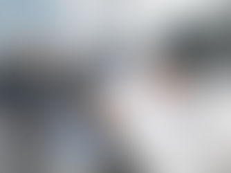 Vista ravvicinata di un colloquio di lavoro su una scrivania nera. In primo piano, le mani di un recruiter in camicia bianca che tengono una penna e un curriculum vitae stampato