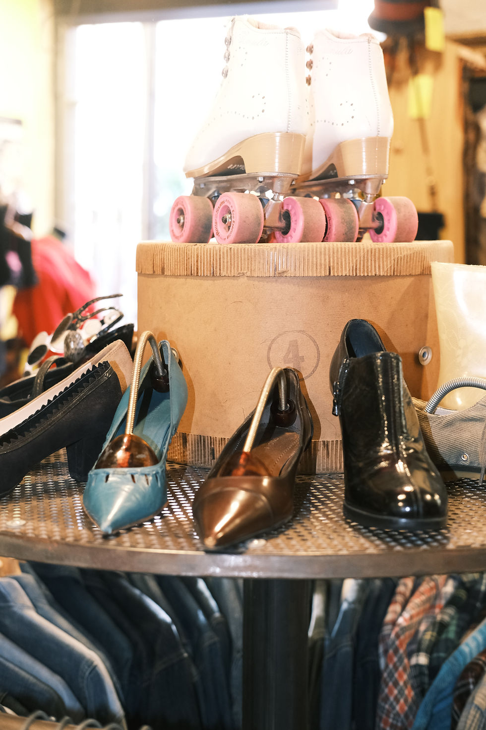 Display of retro white and pink roller skates and vintage Italian leather shoes.