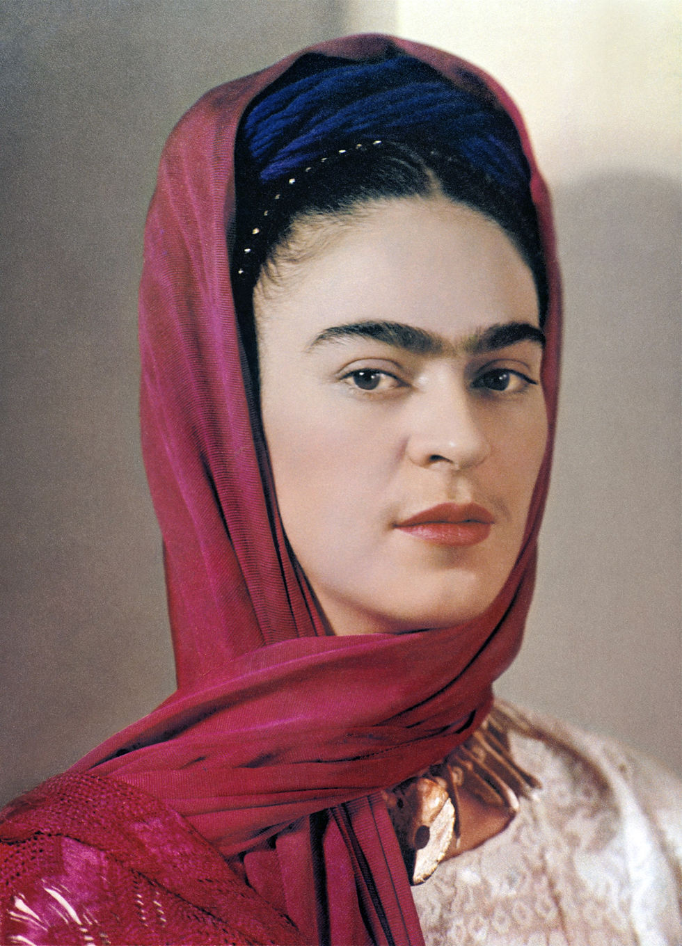 Striking portrait of Mexican painter Frida Kahlo wearing red head scarf.