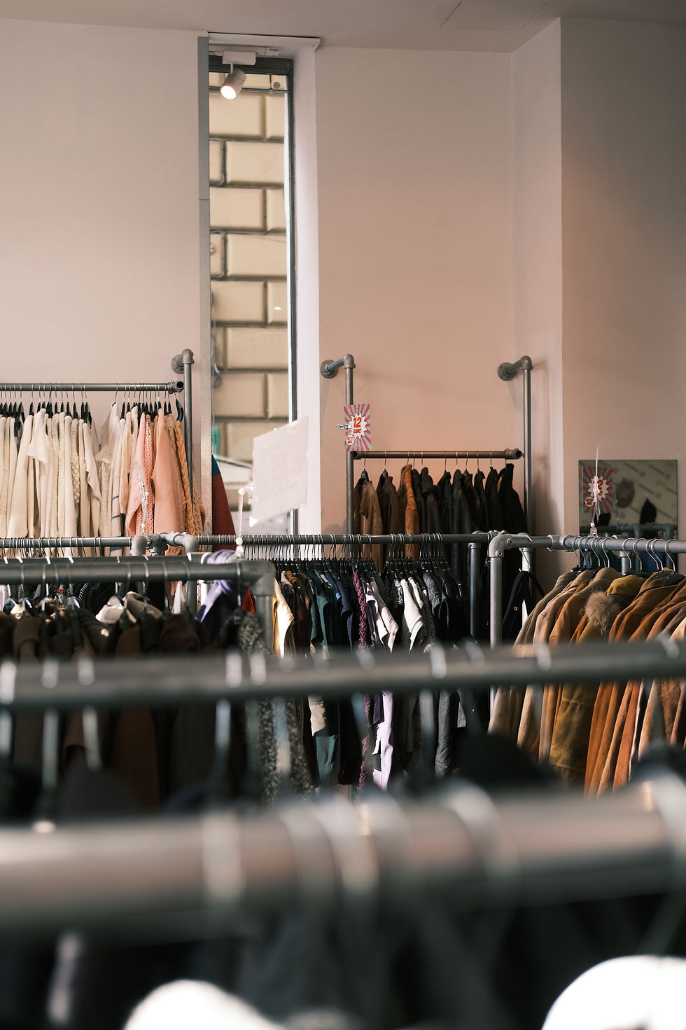 Overhead shot of wracks of clothing in Rome thrift store.