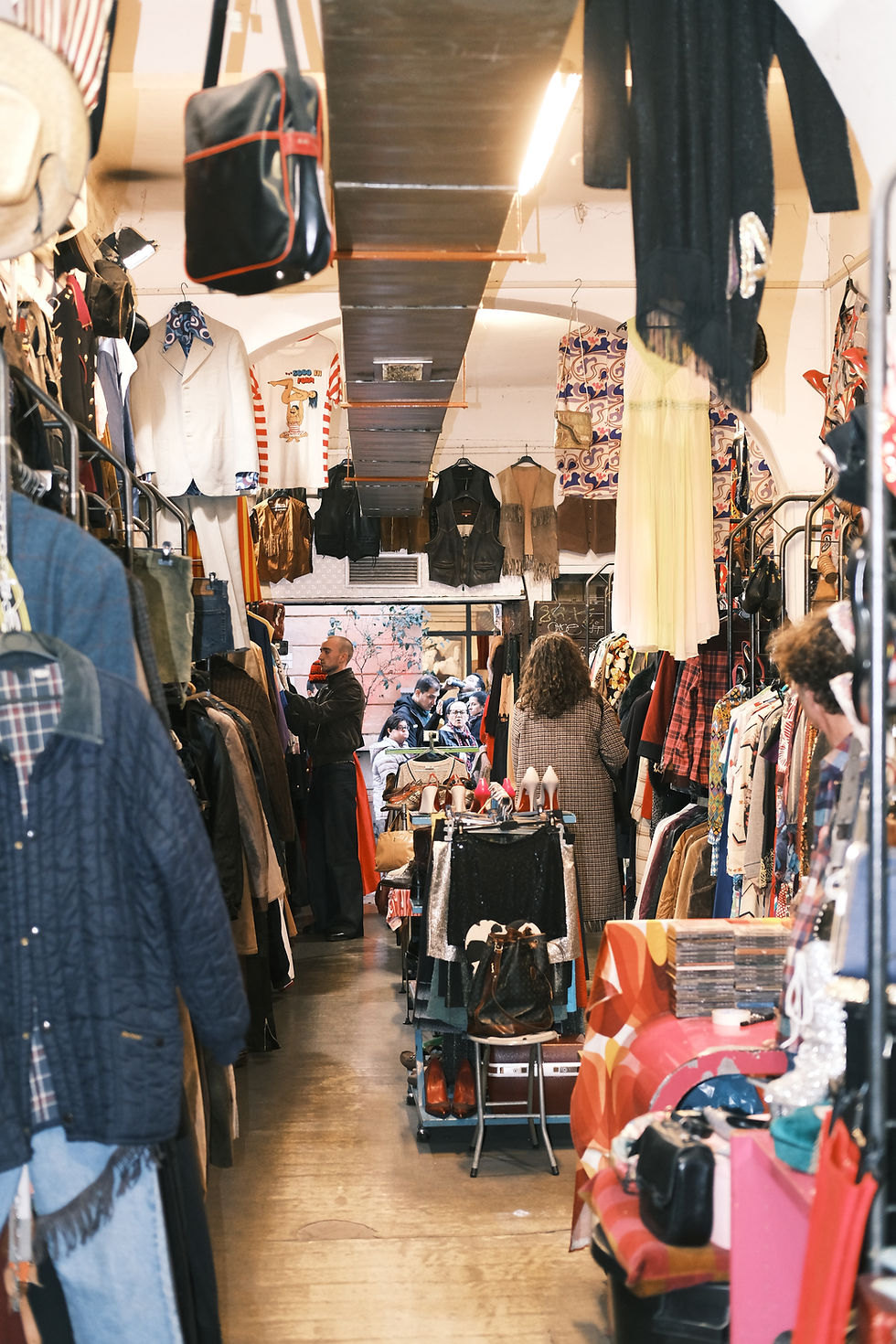 Narrow vintage storefront filled with vibrant costume clothing.