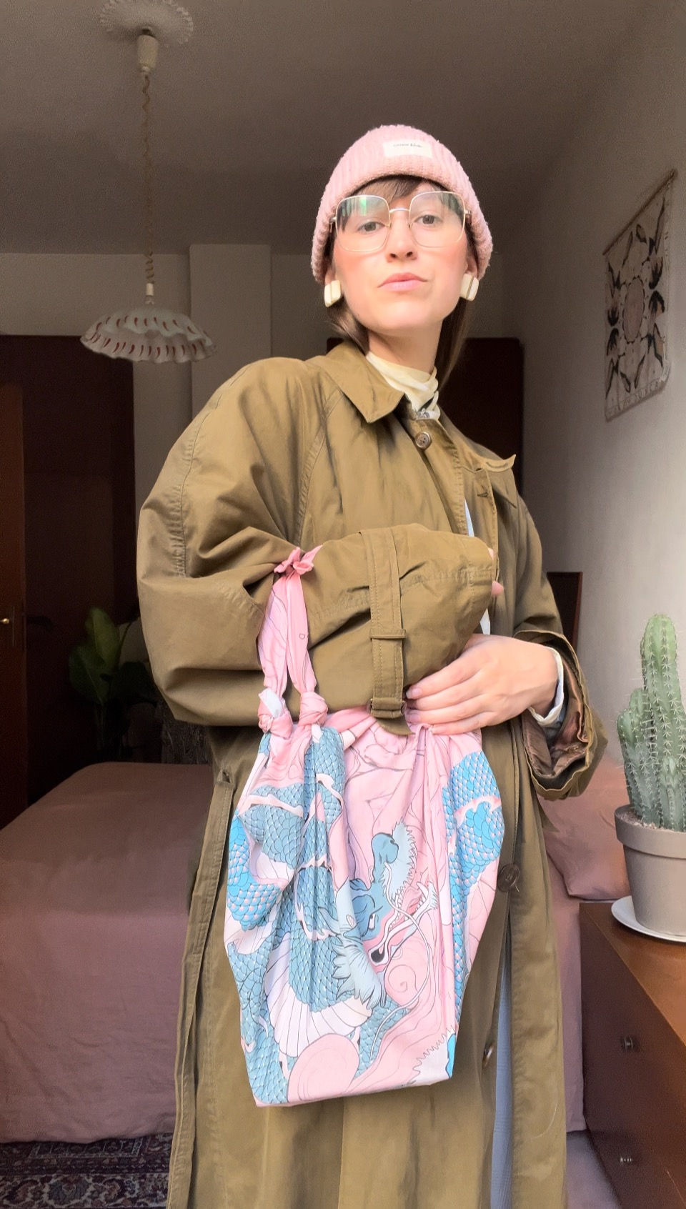 Woman wearing winter outfit with a silk scarf knotted bag.