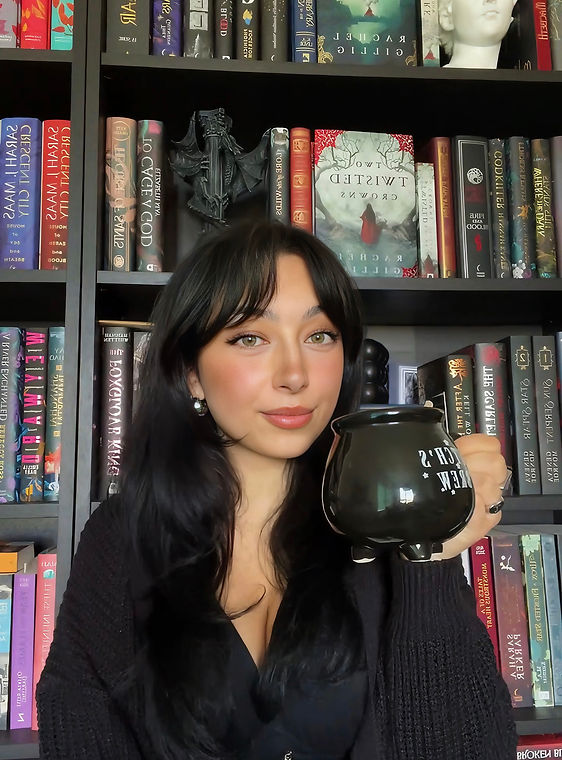 Picture of Alessia - Woman holding a mug in the shape of a cauldron standing before a library