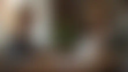 Jovem praticando shadowing em inglês com fones e espelho ao lado de frases na tela