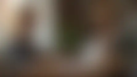 Jovem praticando shadowing em inglês com fones e espelho ao lado de frases na tela