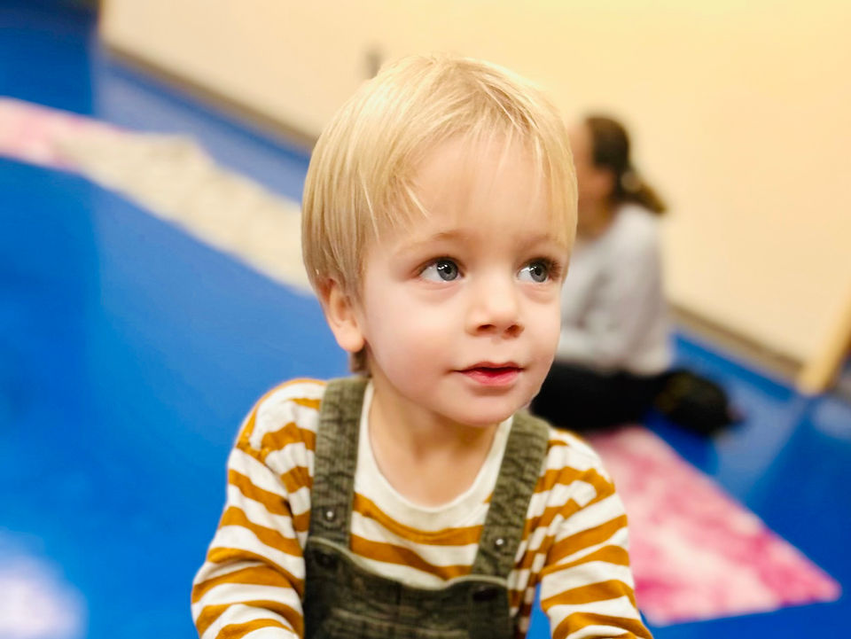 toddler playing the drum in music class in Brookline Boston