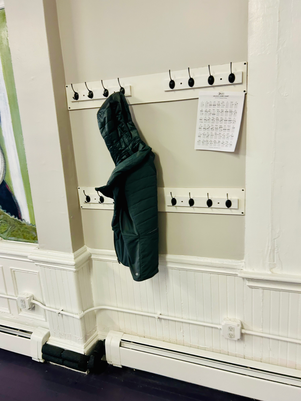 Coat hooks with a green jacket at Charlestown Play Space