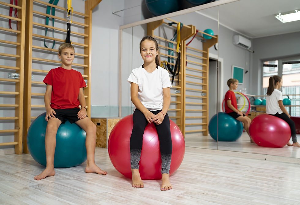Children sitting on exercise balls in a therapy gym
