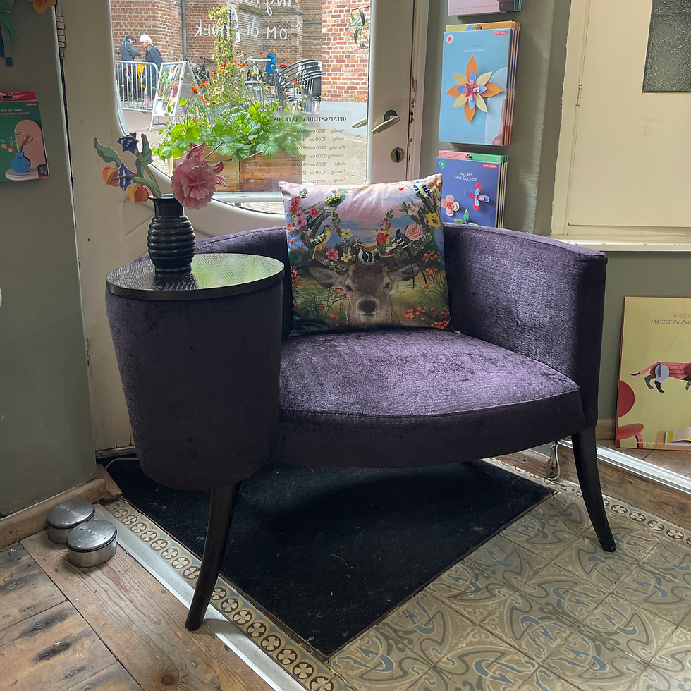 Paarse fauteuil met bloemen en patroon kussen