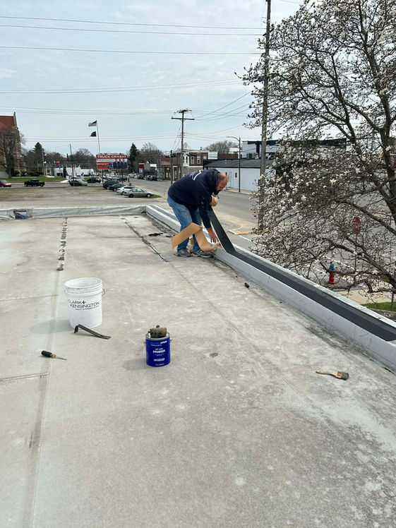 Owner of Precision Roofing And Remodeling repairing a flat roof