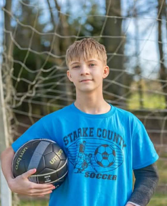 Koen. Boy with short blonde hair and blue eyes holding a soccer ball.