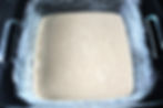 vegan cobbler batter poured into a 8x8 baking pan prepared with sugar