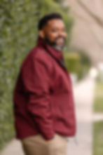 Smiling man in a red jacket by a dating profile photographer