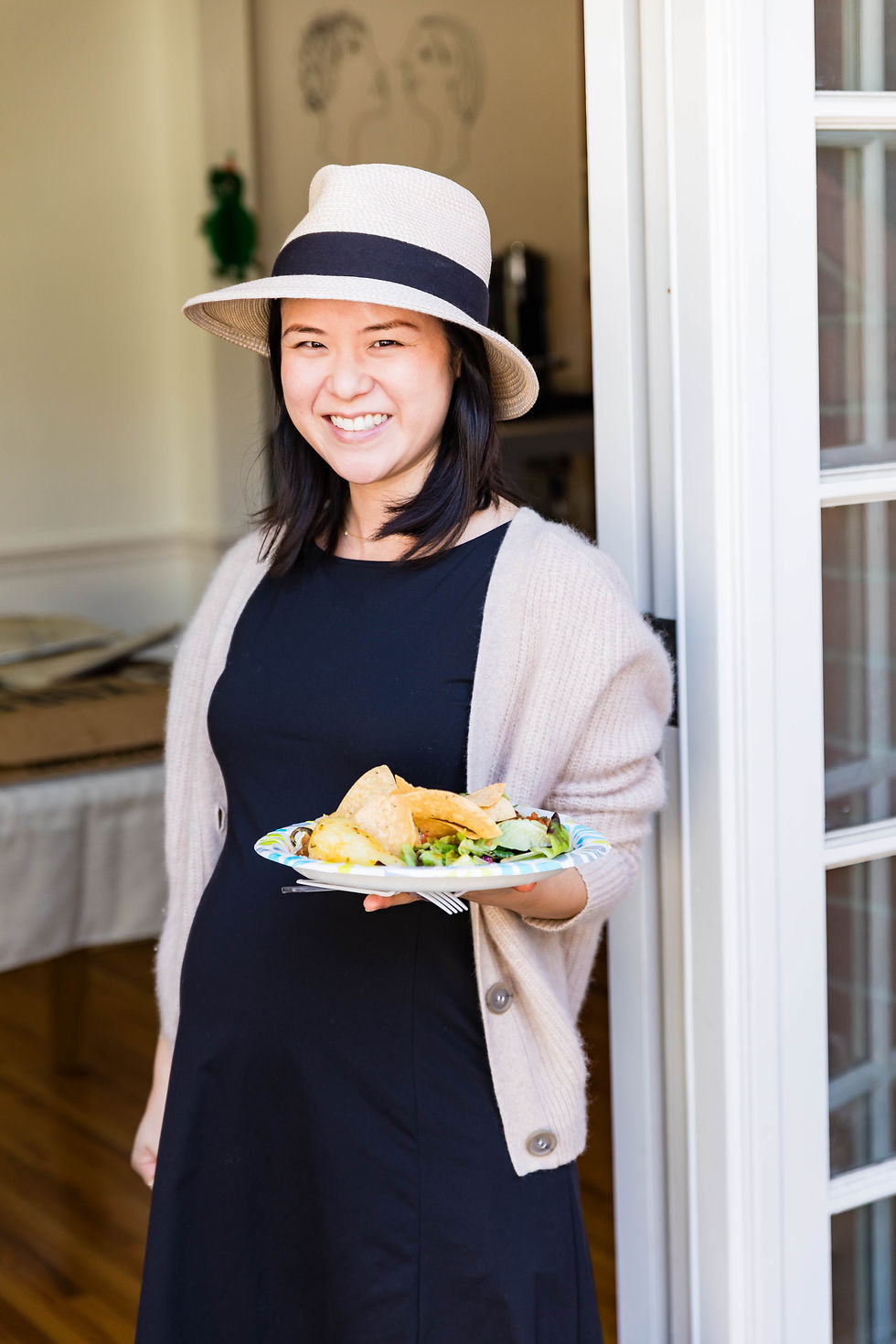 Smiling woman at an event holding a plate of food.