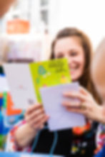 Smiling woman reading a card at a birthday party.