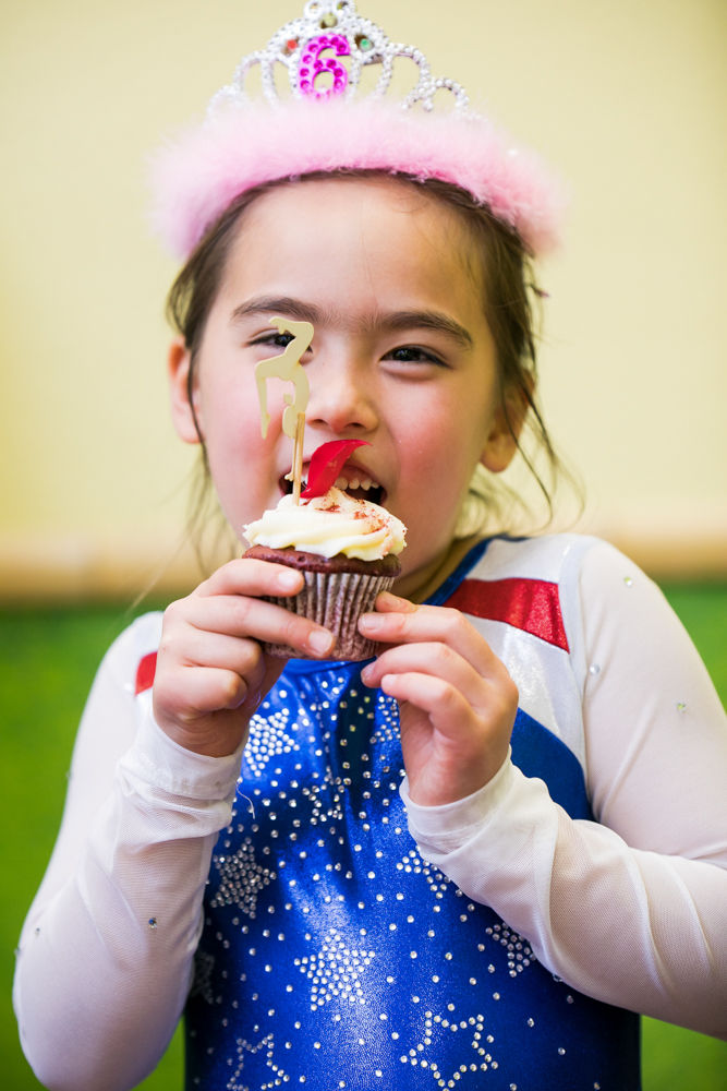 Girl eating a cupcake at a party by an event photographer
