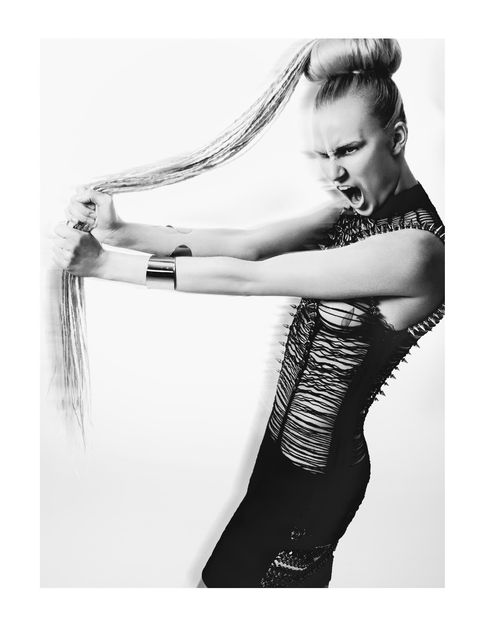 a black and white photo of a woman holding her hair