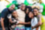 Smiling family group at a birthday party with balloons.