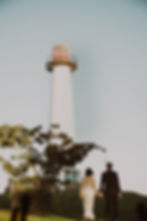 Couple walking toward a lighthouse by a couples photographer