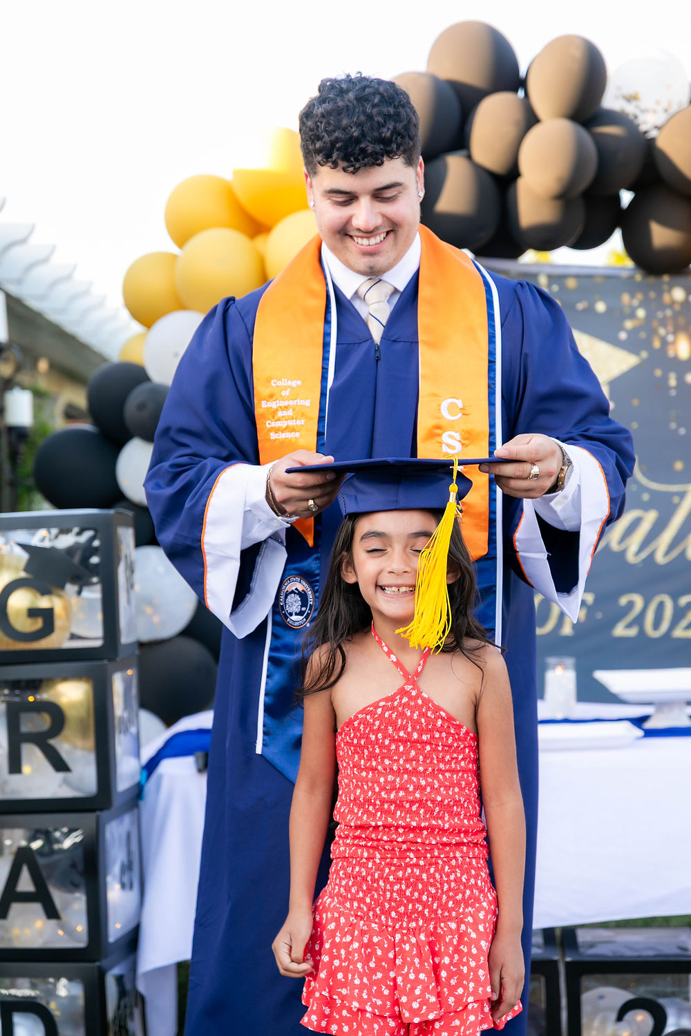 Graduate placing cap on girl at a graduation party