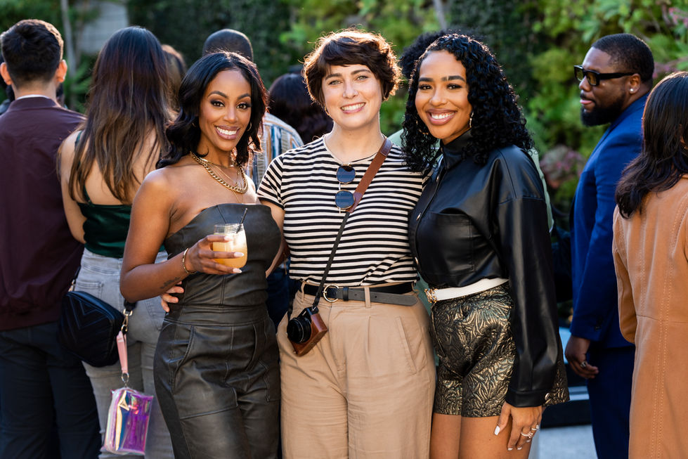 three women posing for a picture with one holding a drink