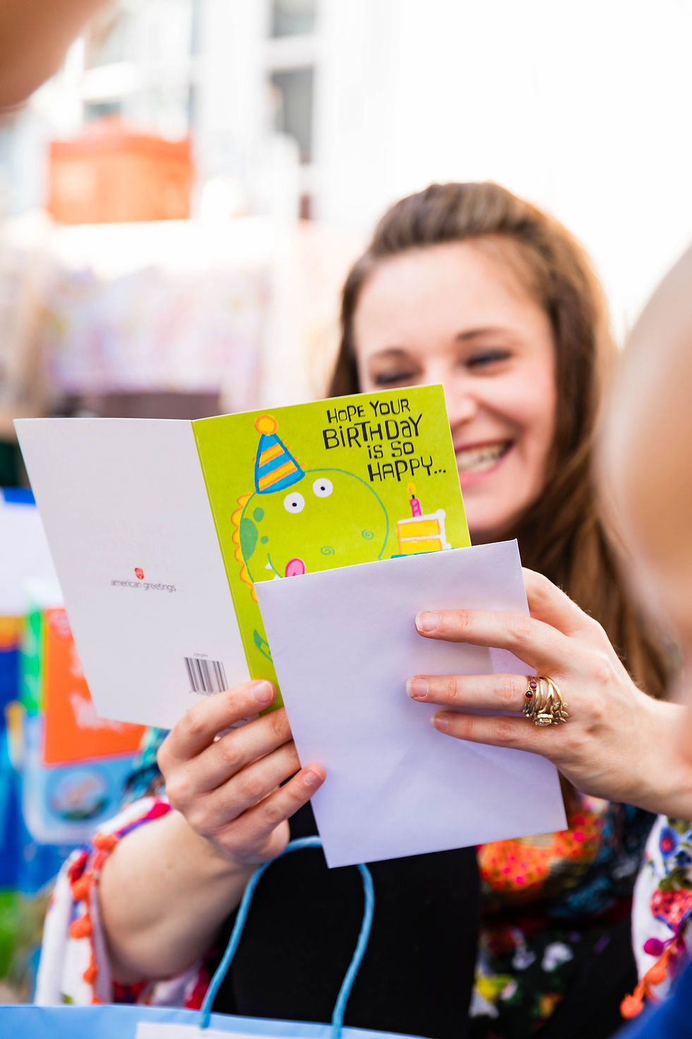 Smiling woman reading a birthday card at a captured event