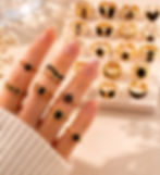 Hand with gold and black rings, part of a jewelry collection