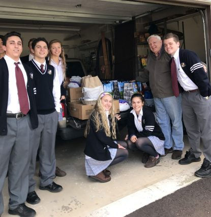 Students of Pope John Paul II High School load into a truck some of the meals collected for the needy.