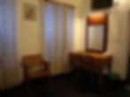 Dressing table, mirror, wooden chair, and patterned curtains