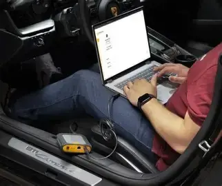 Car fault code expert diagnosing with laptop