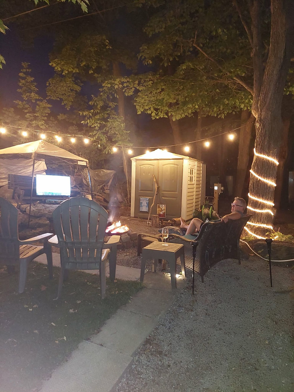 Seasonal family evening by a fire, string lights, and outdoor TV