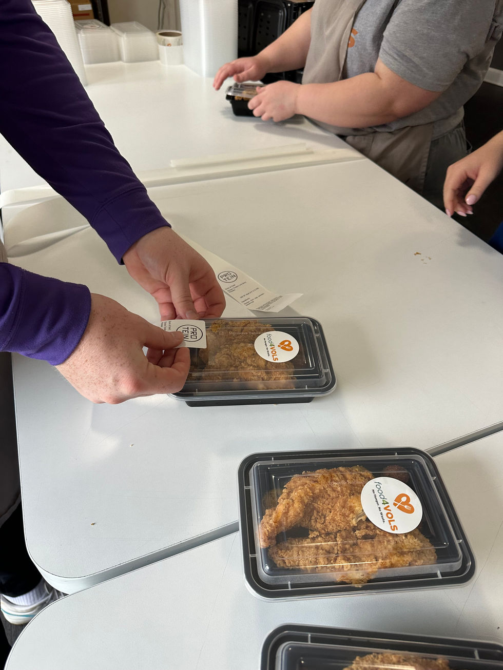 Placing stickers on packaged meals for students and staff at UTK's food4vols