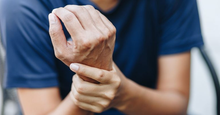 Man holding sore right wrist