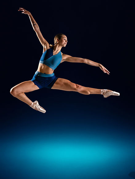 Ballet dancer Pastelle captured at the peak of a powerful studio leap.