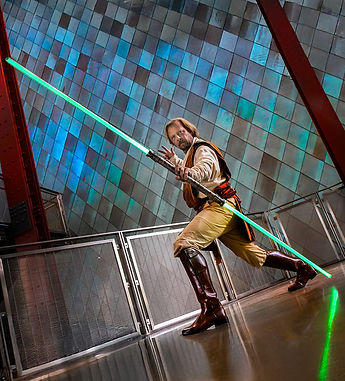 Creative portrait of Tom in Jedi costume holding a light sabre in a university science center.